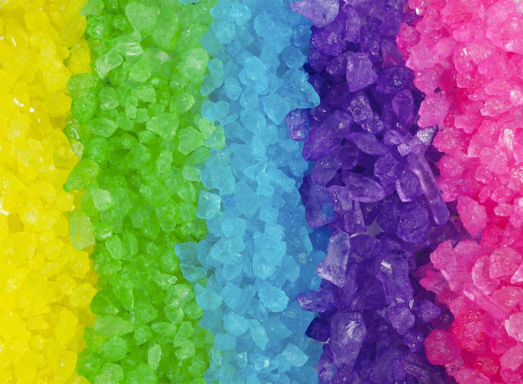rainbow display of yellow, green, blue, purple and pink rock candy
