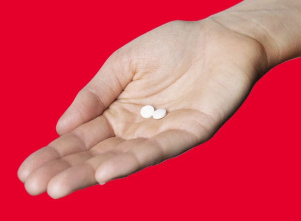 two BioFe iron chewable tablets in the palm of a hand