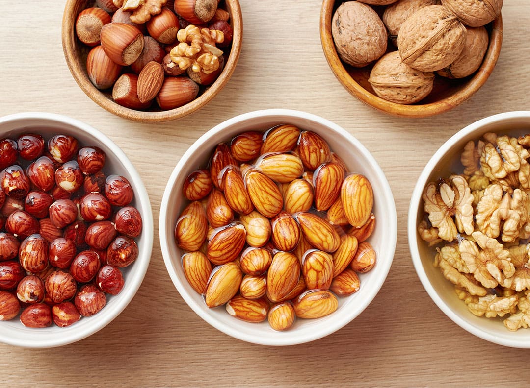 bowls full of different types of nuts soaking in water